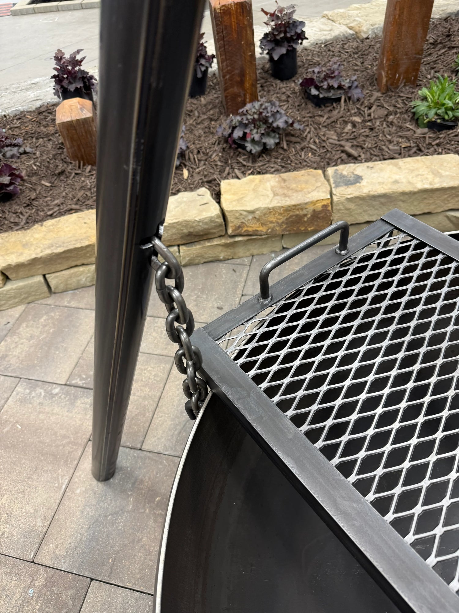 Up Close View of Grill Grate Edge Laying Across the Fire Bowl of our Hanging Tripod Fire Pit Model - Rough & Rigid