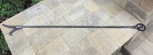 A long metal fire poker placed on a stone surface - 44